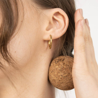 Person using a Myga cork massage ball for targeted neck self-massage